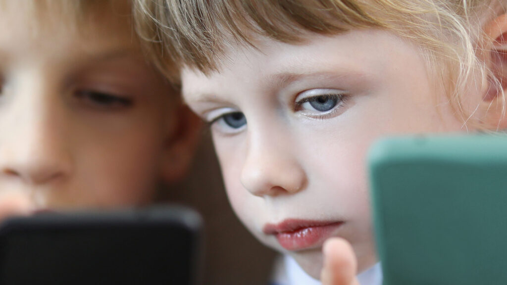 Young children looking at smart phones